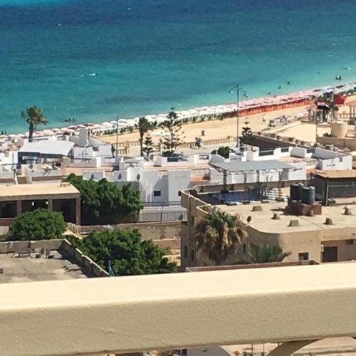 زهرة مطروح للشقق الفندقية في مرسى مطروح: اطلالة على شاطئ به مباني بيضاء والمحيط