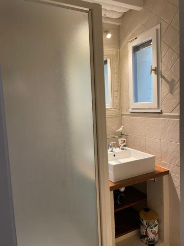 ein Bad mit einem Waschbecken und einer Glastür in der Unterkunft JOLIE MAISON AU GOLF in Lacanau-Océan
