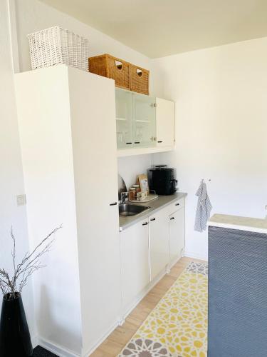a kitchen with white cabinets and a kitchen rug at Randers residence Sankt Andreas - 2 room apartment in Randers