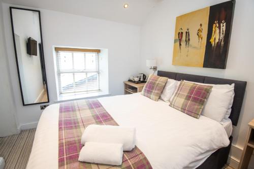 a bedroom with a large white bed and a window at Healds Hall Hotel in Cleckheaton