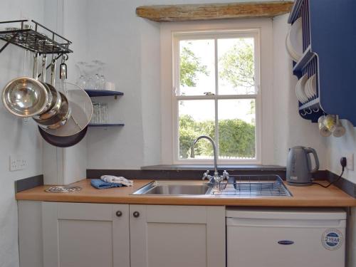 a kitchen with a sink and a window at Gamekeepers Cottage in Newchapel