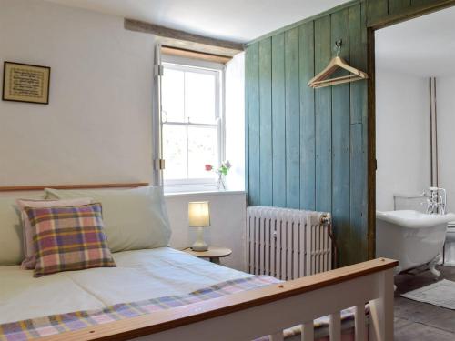 a bedroom with a bed and a sink and a window at Gamekeepers Cottage in Newchapel