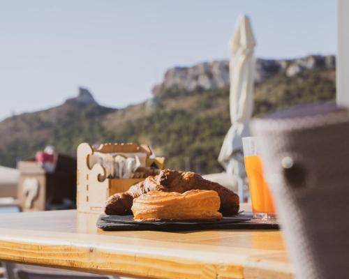 a table with a plate of pastries and a glass of orange juice at Le Palmette Suites in Cagliari