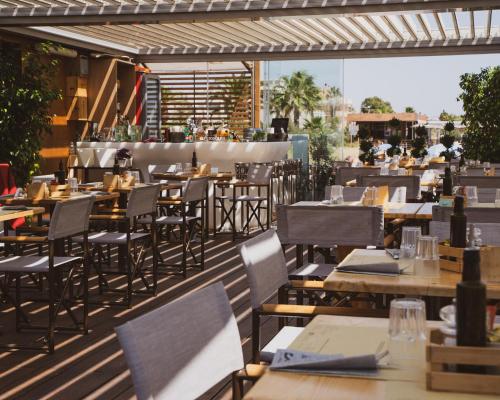 a restaurant with tables and chairs on a patio at Le Palmette Suites in Cagliari