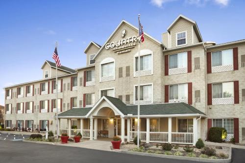 a front view of a hotel with two american flags at Country Inn & Suites by Radisson, Columbus Airport, OH in Columbus
