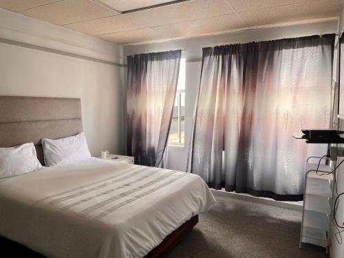 a bedroom with a large bed and a window at Stay Inn Lodge Randfontein in Randfontein