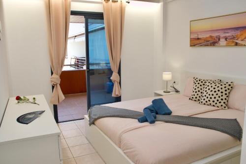 een slaapkamer met een bed met een blauwe teddybeer erop bij Apartment Theresa Los Gigantes in Puerto de Santiago