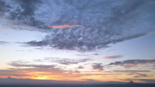 a cloudy sky with a sunset in the background at Río Celeste Nature View in Upala