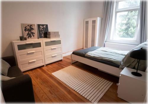 1 dormitorio con 1 cama, vestidor y ventana en Altbaucharme! 2Zimmer, zentral und 24h Check-in, en Kiel