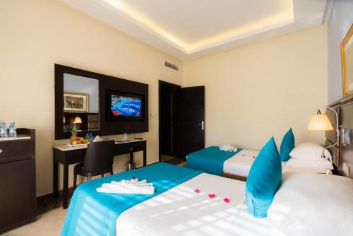 a hotel room with two beds and a television at Pickalbatros Aqua Fun Club All Inclusive in Marrakech
