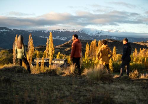 um grupo de pessoas em pé em um campo com montanhas em Explora en Parque Nacional Patagonia em Cochrane