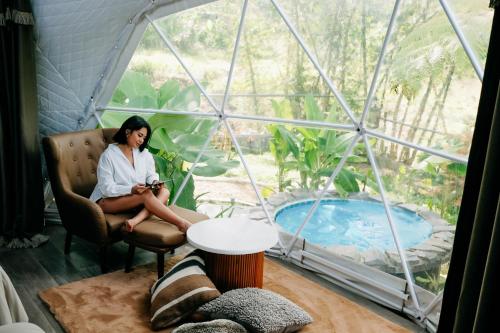 a woman sitting in a chair in a room with a window at 150 Peakway Mountain Resort in Dalaguete