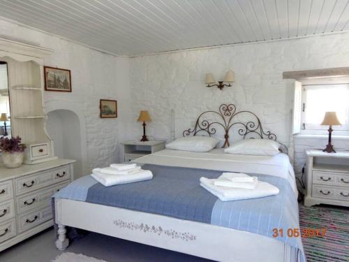 a white bedroom with a large bed and a window at Guesthouse in Drios, Paros island, Greece. in Drios