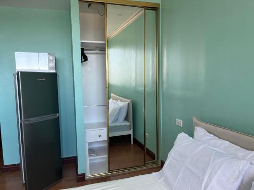 - une chambre avec un miroir à côté d'un lit dans l'établissement The Luxurious byTERBAIK, à Manille