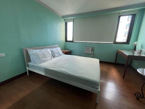 - une chambre avec un lit dans une pièce aux murs verts dans l'établissement The Luxurious byTERBAIK, à Manille