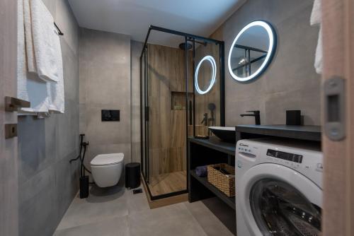 a bathroom with a washer and dryer in a room at Central Suites Aegina 2 in Aegina Town
