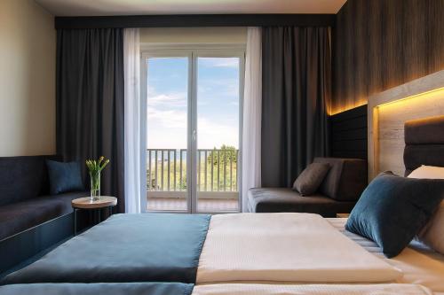 a hotel room with a bed and a balcony at Hotel Haliaetum - San Simon Resort in Izola