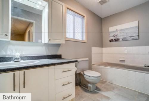 La salle de bains est pourvue de toilettes, d'un lavabo et d'une baignoire. dans l'établissement Comfy Private Bedroom near Downtown Ottawa/Gatineau, à Gatineau