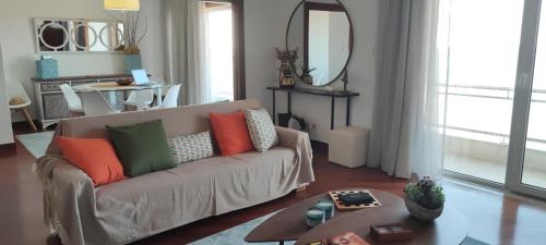 a living room with a couch with colorful pillows on it at Barramares Apartment - Sea View Povoa de Varzim in Póvoa de Varzim