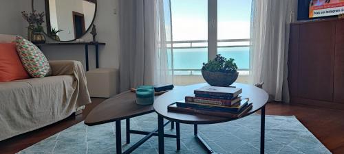 a living room with a table with books on it at Barramares Apartment - Sea View Povoa de Varzim in Póvoa de Varzim