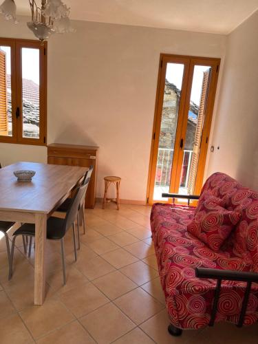 a living room with a table and a red couch at Casa Marcela in Gravedona