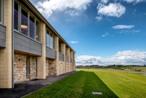 un edificio con un campo erboso accanto di Ashley House a Dundee
