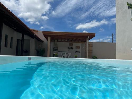 a swimming pool in front of a house at Casa Confortável e Aconchegante in Brotas