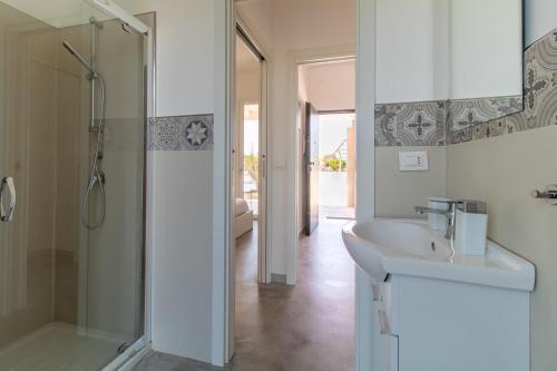 a white bathroom with a shower and a sink at Villa Verde Oliva in Ispica