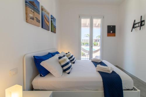 a bedroom with a bed with blue and white pillows at Villa Verde Oliva in Ispica