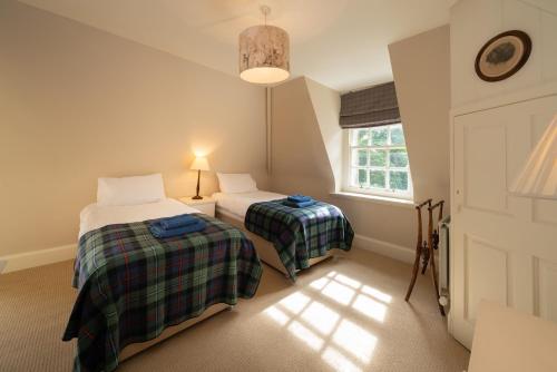 a bedroom with two beds and a window at Gatehouse, Bridge of Balgie, Glenlyon 