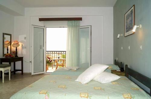 1 dormitorio con cama con almohadas y balcón en Pygolampida Studios, en Mytilini