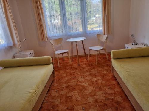 pokój z dwoma łóżkami, stołem i krzesłami w obiekcie Ośrodek Wypoczynkowy Soszko w mieście Swornegacie 