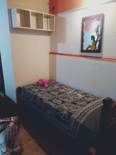 Dormitorio pequeño con cama con espejo en la pared en Departamentos Termas en Termas de Río Hondo