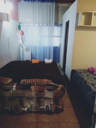 1 dormitorio con 2 camas y ventana en Departamentos Termas en Termas de Río Hondo