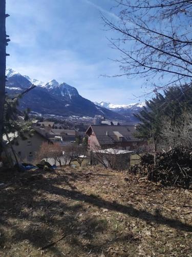 une vue d'un village avec des montagnes en arrière-plan dans l'établissement cabane de charme, à Briançon