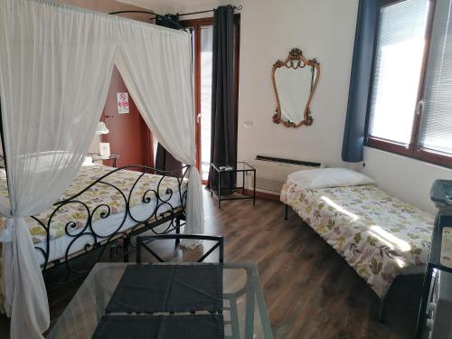 Pokój z 2 łóżkami, stołem i lustrem w obiekcie BGY Airport Guesthouse w mieście Orio al Serio