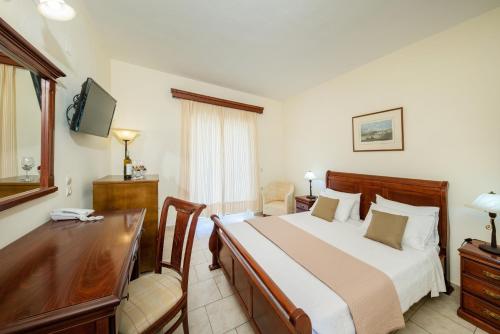 a hotel room with a bed and a desk and a desk at Aqualand Resort in Agios Ioannis