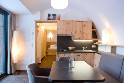 een keuken met een tafel en stoelen in een kamer bij Gurgltal Refugia in Tarrenz
