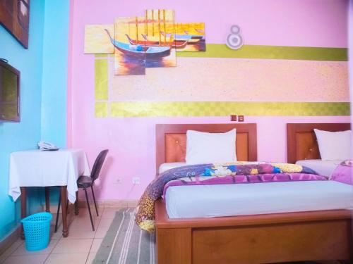 ヤウンデにあるHOTEL DE LA VALLEE NEWのベッドルーム1室(壁に絵画が描かれたベッド1台付)
