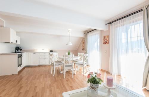 - une cuisine et une salle à manger avec une table et des chaises dans l'établissement Appartements Allmaier, à Pörtschach am Wörthersee