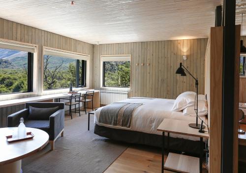 a hotel room with a bed and a desk and chairs at Explora en El Chalten in El Chalten