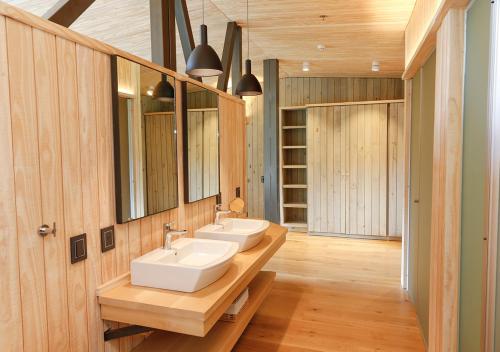 a bathroom with two sinks and two mirrors at Explora en El Chalten in El Chalten