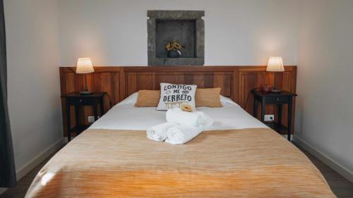 a bed with two stuffed animals sitting on top of it at Casas do Forneiro A Casa Para 2 Pessoas in Nordeste