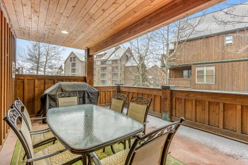 un patio con tavolo e sedie in vetro su un balcone di Mill Creek #203 a Keystone