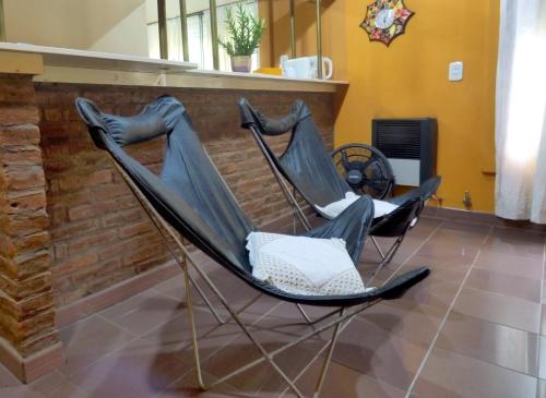 dos sillas sentadas junto a una pared de ladrillo en Alojamiento Passiflora I en Villa Elisa