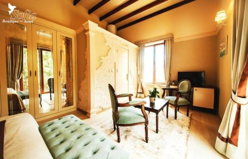 a bedroom with a bed and a table and chairs at SOFIA BOUTIQUE HOTEL in Kérynia