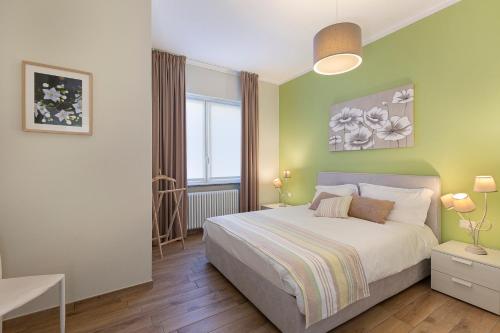 a bedroom with a bed and a green wall at Bellavista Apartments - By Impero House in Levo