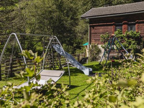 a playground with a slide in a yard at Gästehaus Waldruh in Gerlos