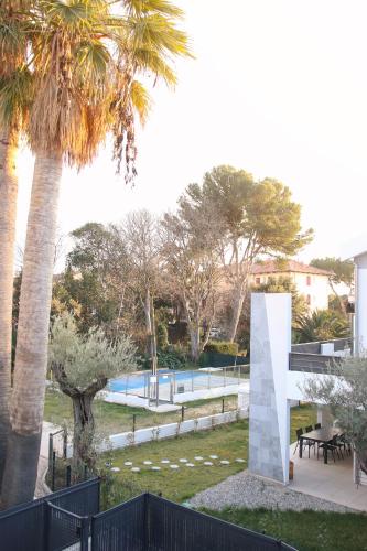 - une vue sur un parc avec un palmier dans l'établissement T3 30 dans résidence neuve près des plages, à Saint-Cyr-sur-Mer