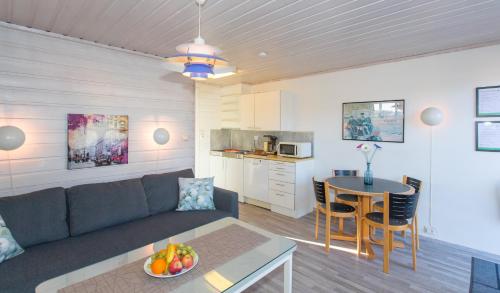 una sala de estar con un sofá y una mesa en Topcamp Bie - Grimstad, en Grimstad